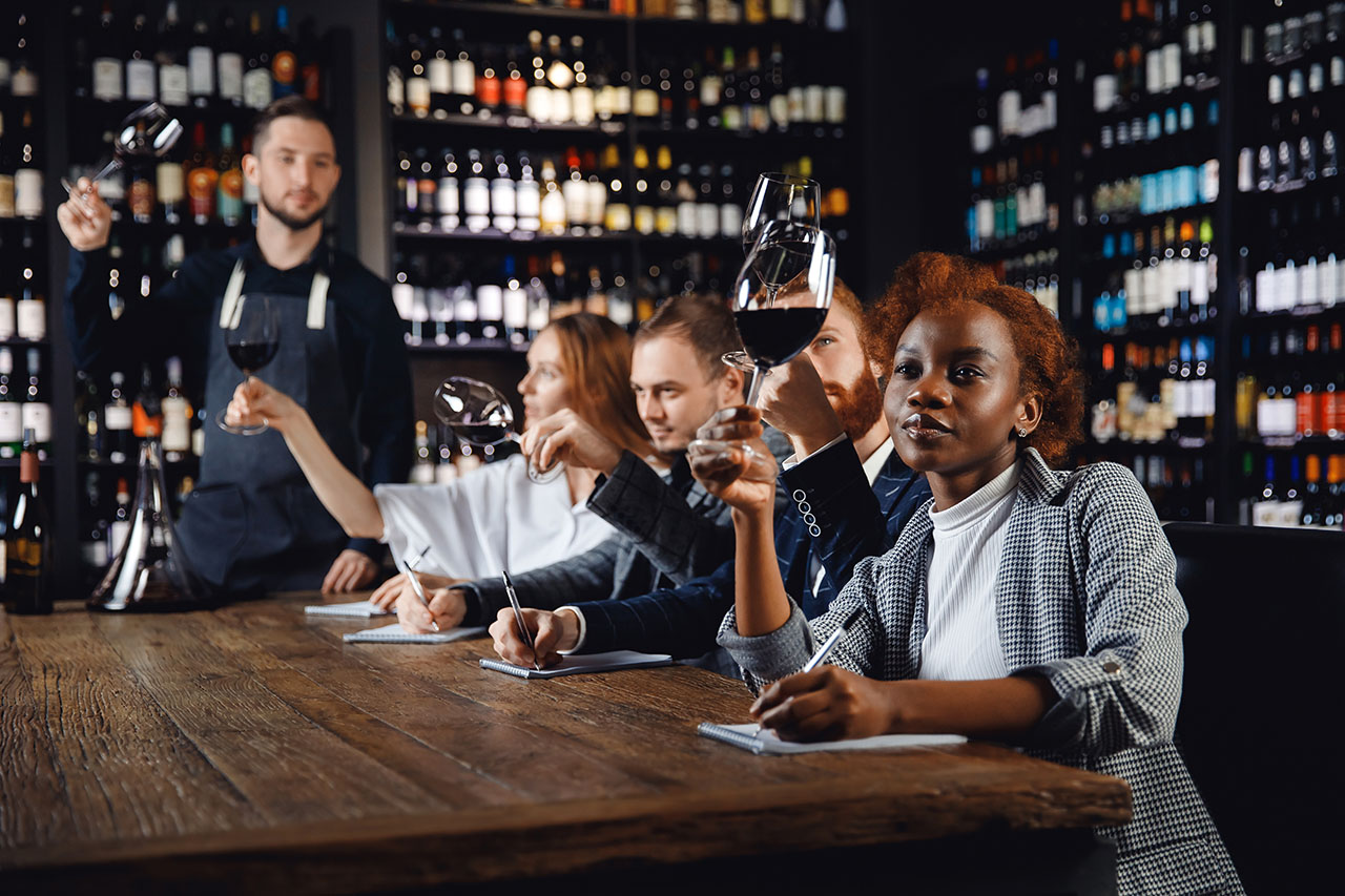 Coach or trainer helps 4 employees learn about wine. Cypress Coast Wine Group in Monterey and Nathan Millan help your guests enjoy wine fully.